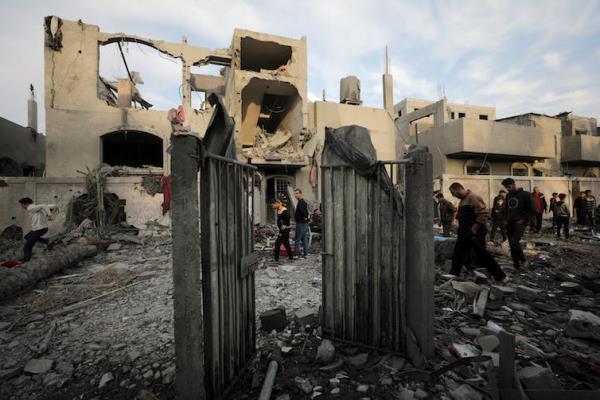 The co<em></em>ncrete rubble of a bombed building, with a small group of people inspecting it
