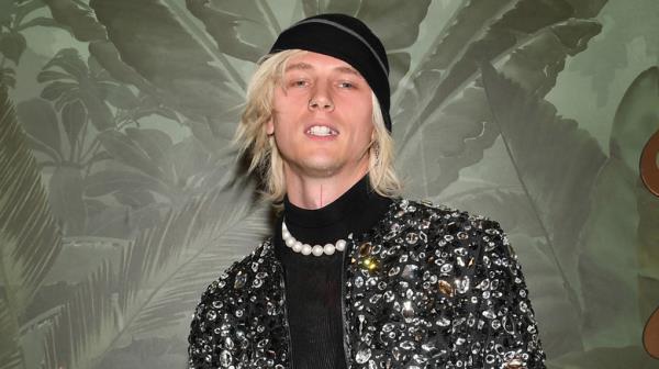 Machine Gun Kelly hat pearl necklace smiling