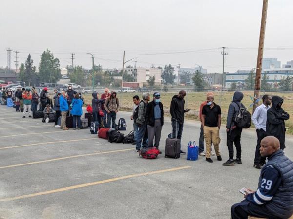 People line up for a flight out of Yellowknife